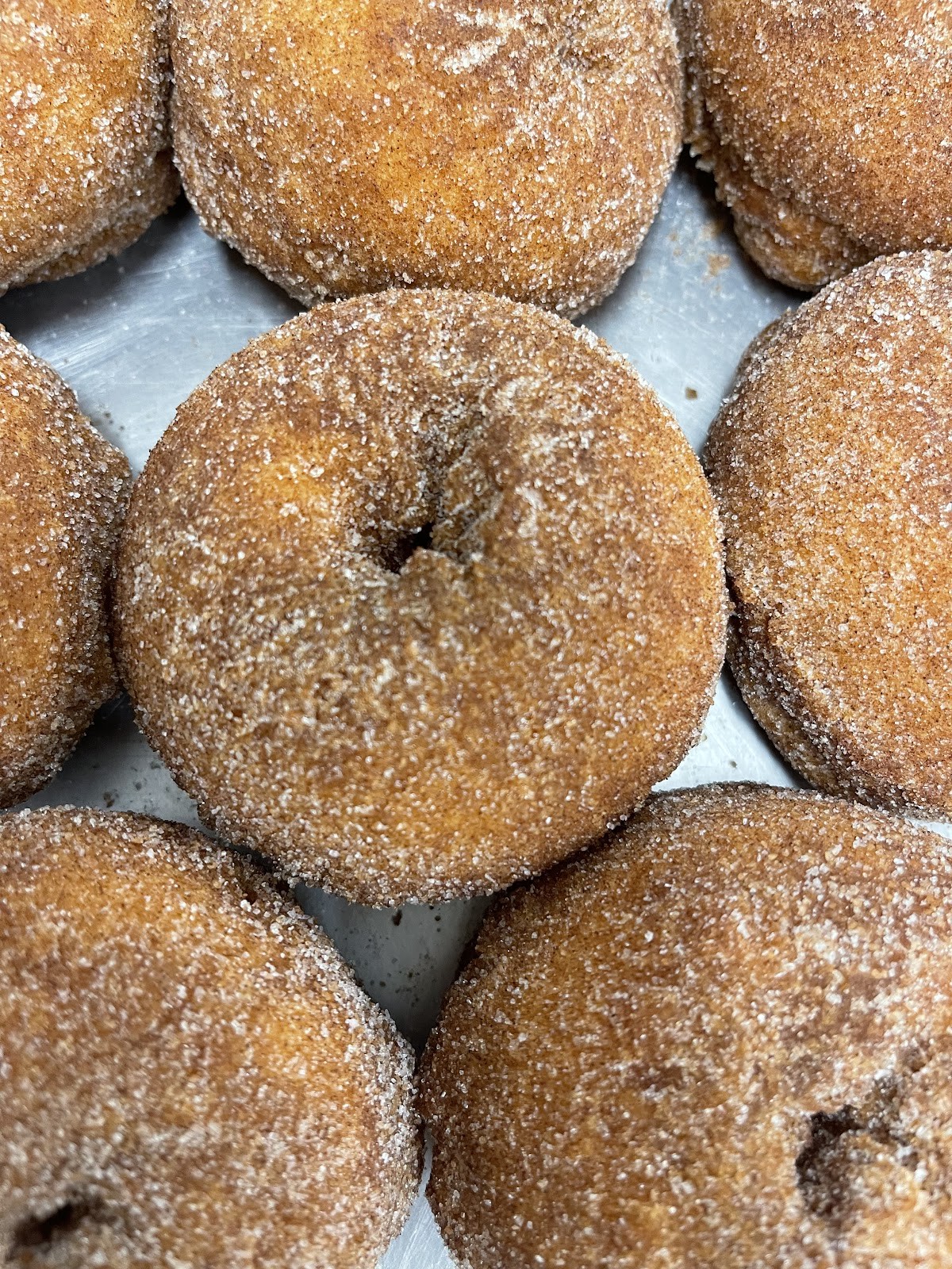 Stacked cinnamon-sugar old fashioned cake donuts, warm and golden